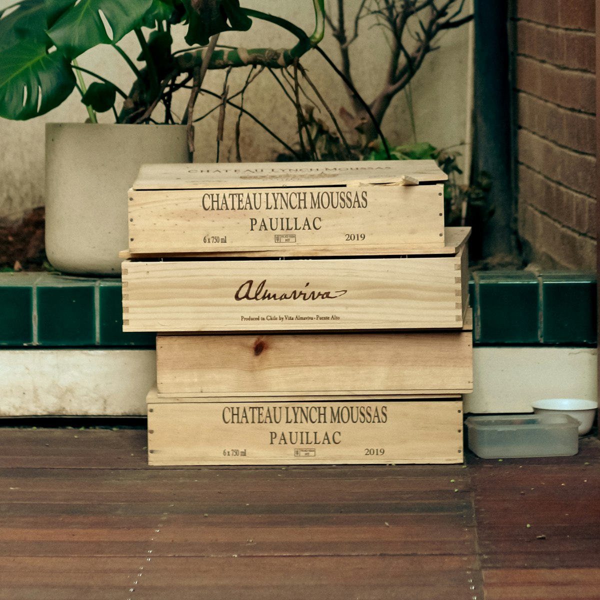 Wooden cases of Bordeaux wine stacked on a terrace